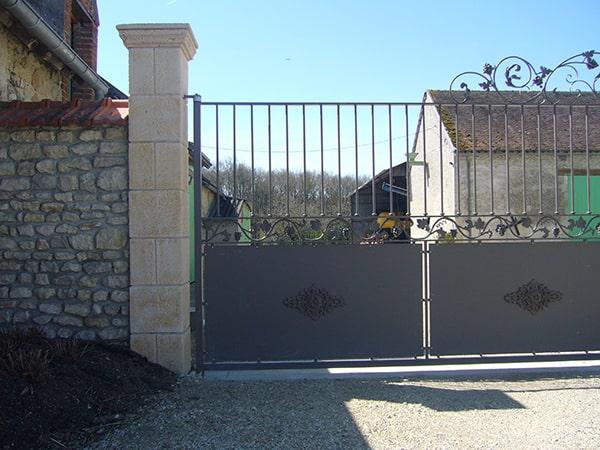 Pose du portail par scellement dans les pilastres en pierre de taille