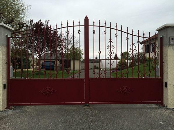 Fabrication sur-mesure portail motorisé 2 vantaux avec chapeau de gendarme, volutes. Electrozingage de l'ensemble contre la corrosion puis thermolaquage couleur bordeaux