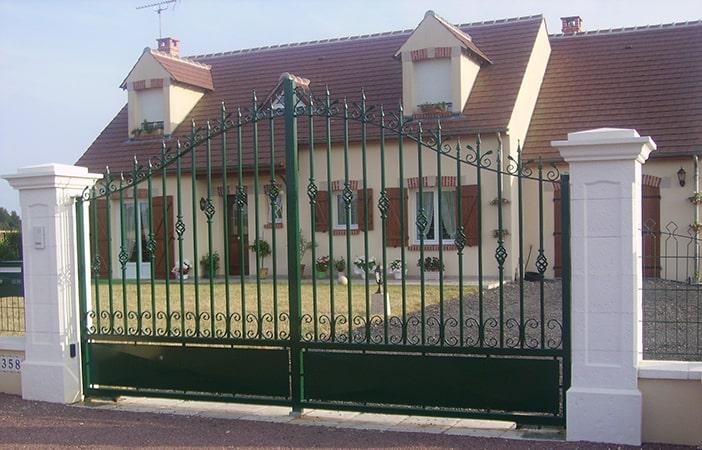 Fabrication et pose portail 2 vantaux avec chapeau de gendarme, volutes forgées. Barraudage en carré avec pointe. Motorisation au sol CAME